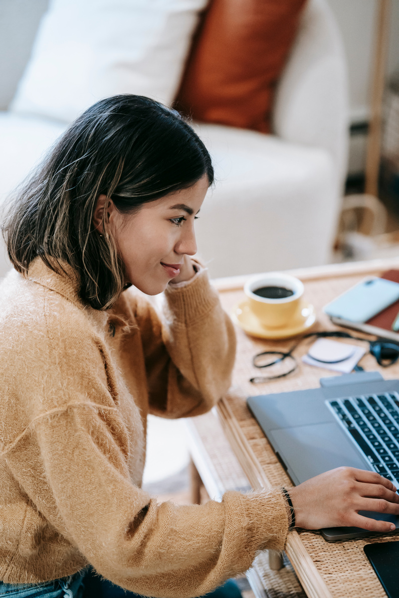 Content ethnic remote employee using laptop at home